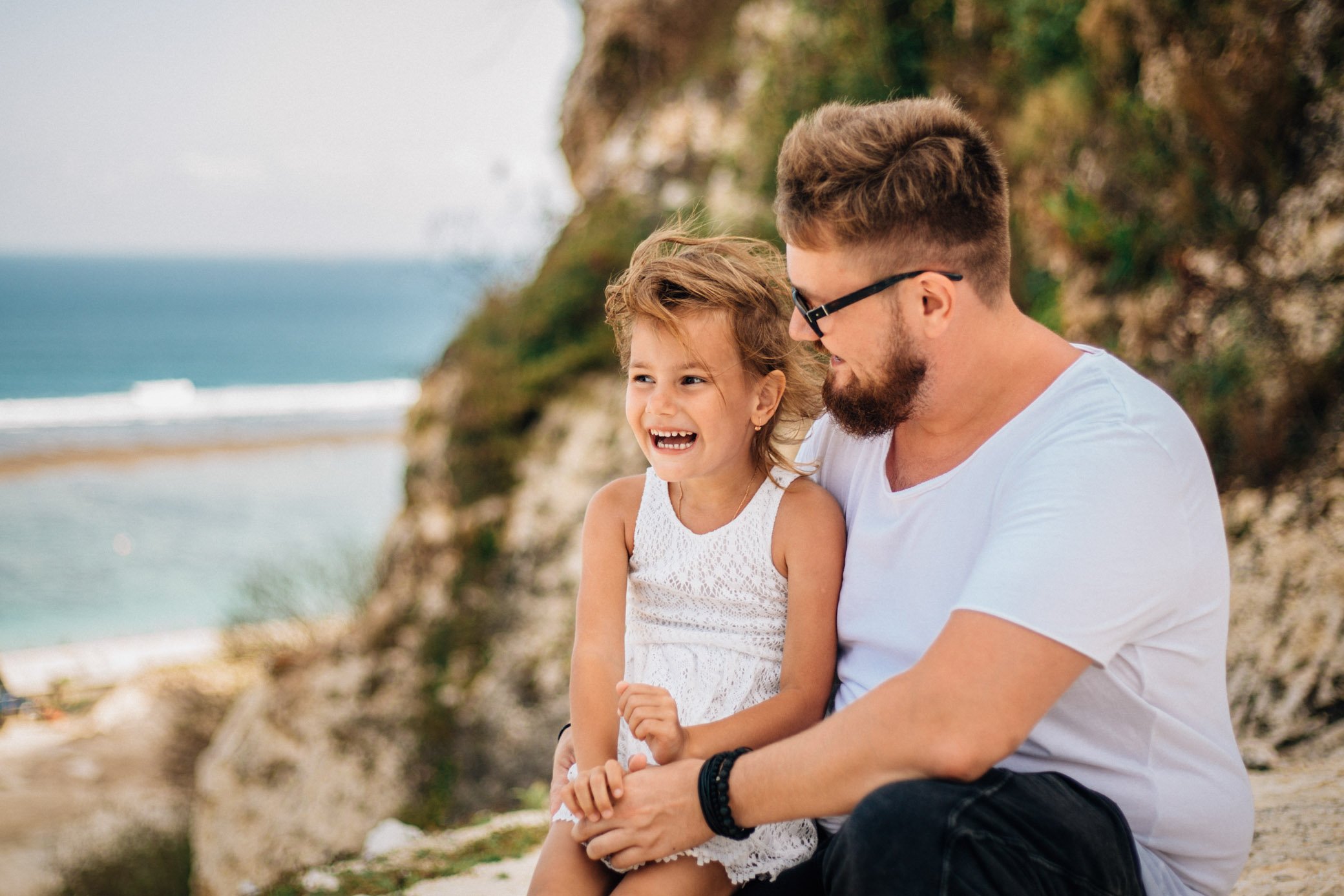 
My daughter sits on my father's knees. They laugh, smile, enjoy life. The girl has white even teeth.