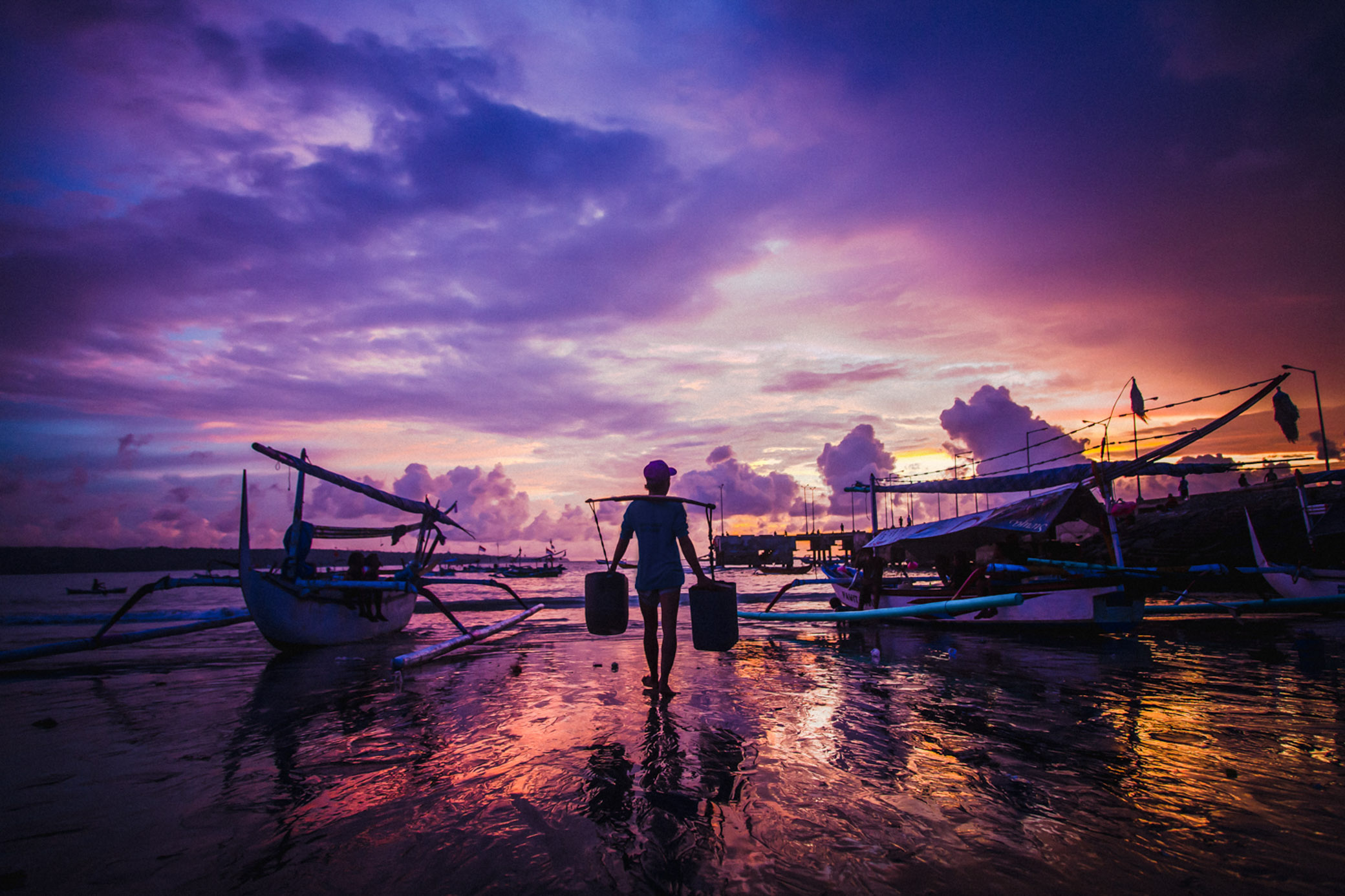 On the coast of Jimbaran, fishermen fish and various seafood in Bali. Sunset, fishing boats
